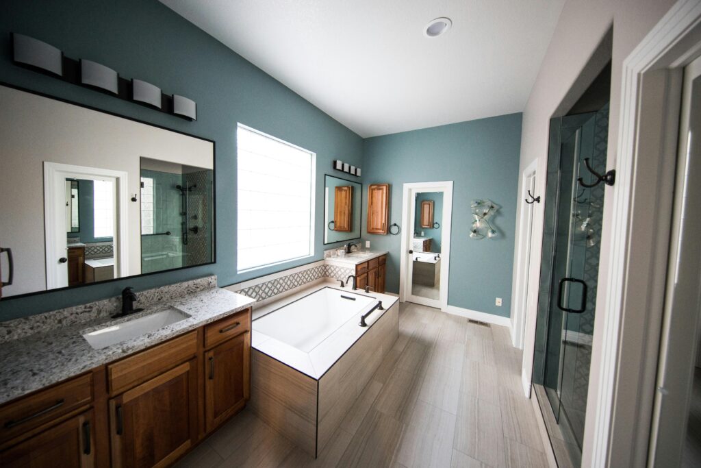 pexels-photo-1909791-1909791 Spacious modern bathroom featuring a freestanding bathtub, wooden cabinets, and granite countertops.