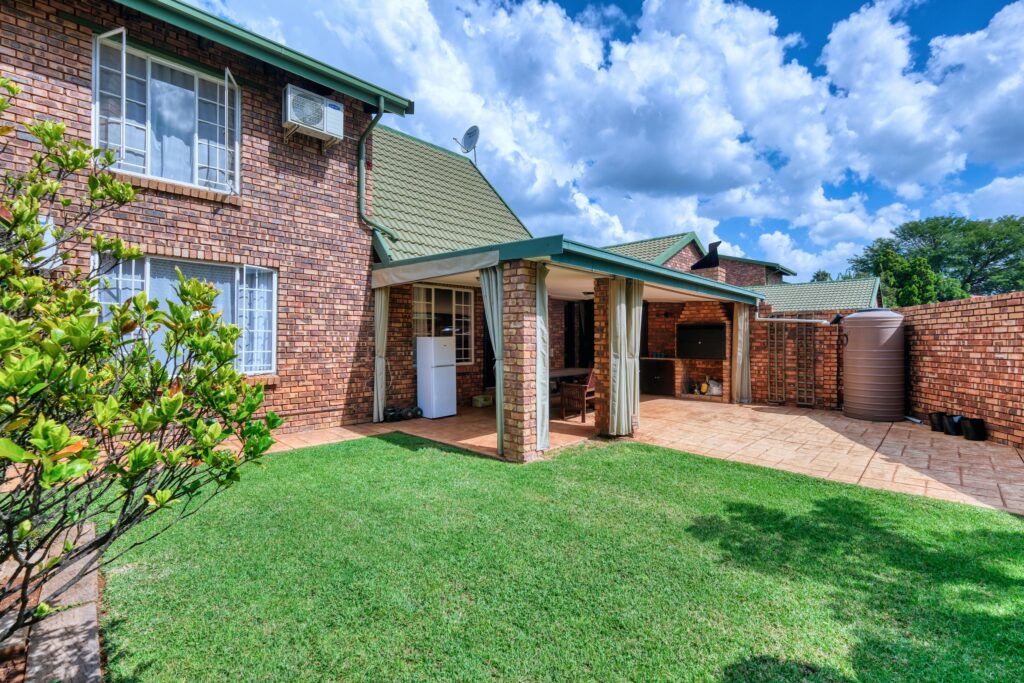 pexels-photo-21297784-21297784 A beautiful suburban brick house with a lush green lawn and patio in Pretoria, South Africa.