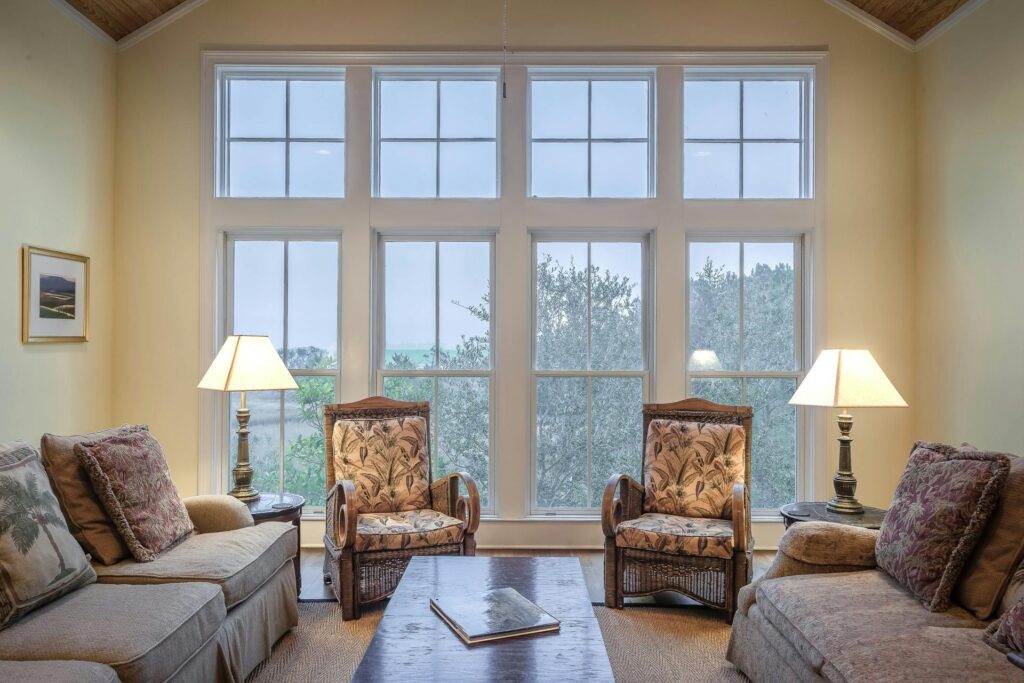 pexels-photo-276551-276551 A cozy living room showcasing elegant furniture with large glass windows and warm lighting.