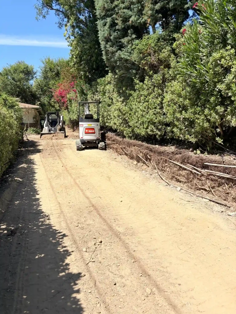 Cleared access area and compact equipment during Southern California custom home site preparation