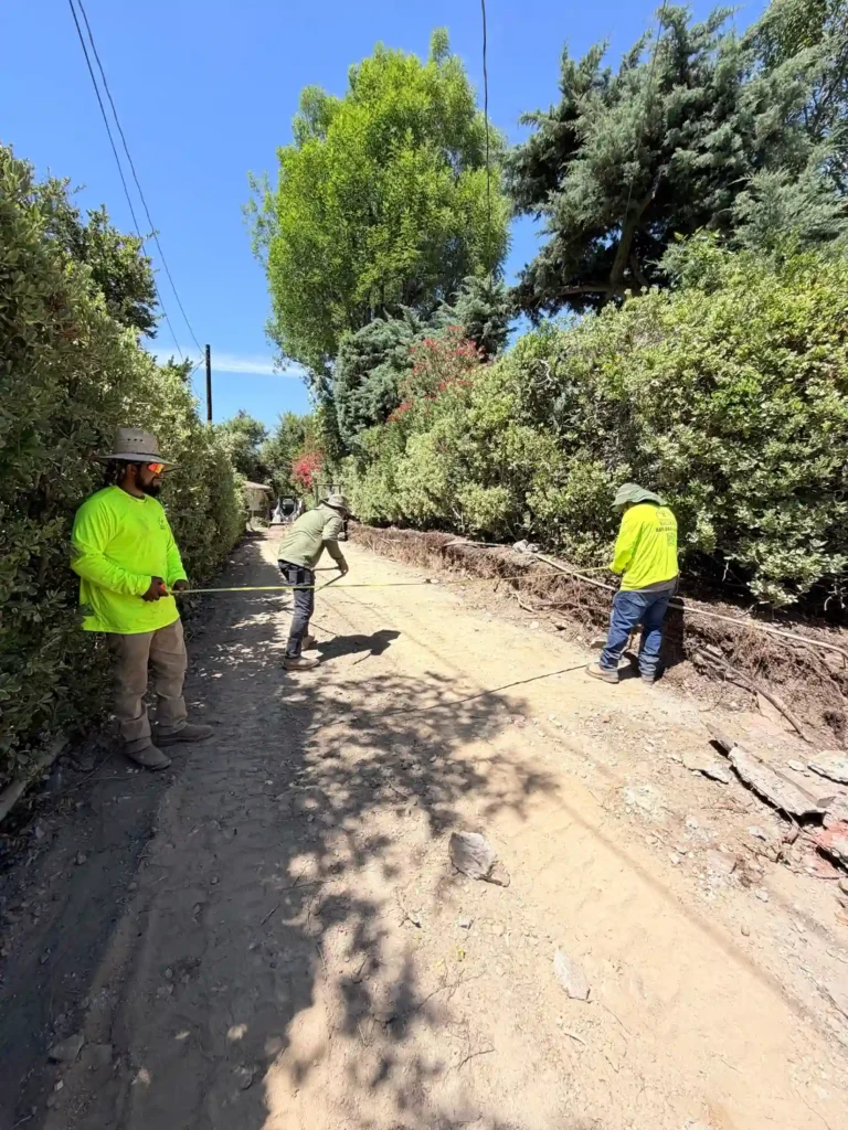 Construction crew coordinating exterior site preparation for a Southern California custom home
