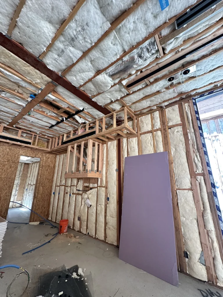 Ceiling insulation, structural framing, and lighting rough-ins during Southern California custom home construction