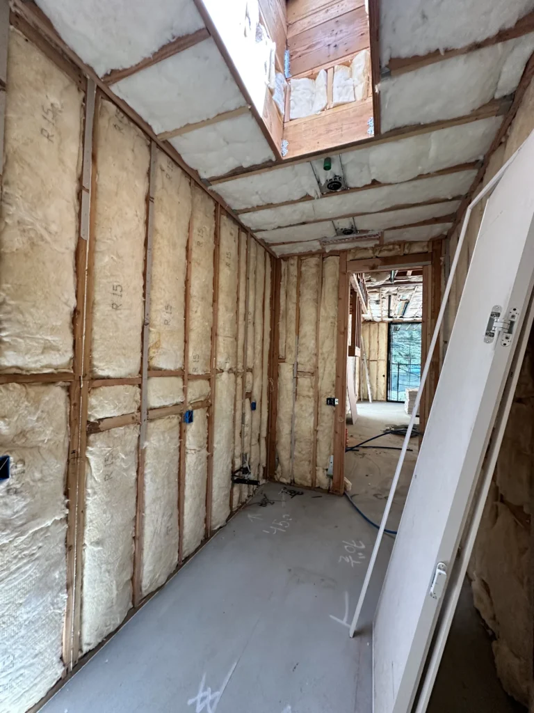 Insulated hallway framing and skylight preparation during Southern California custom home construction