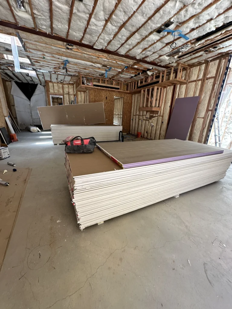 Drywall staged inside an insulated Southern California custom home before wall installation