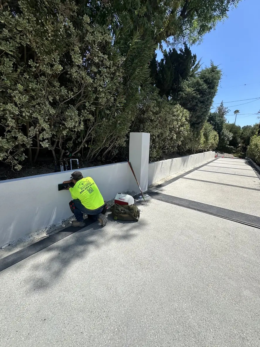Custom Home Builders Los Angeles 16 Wall finishing beside the driveway during an outdoor renovation.