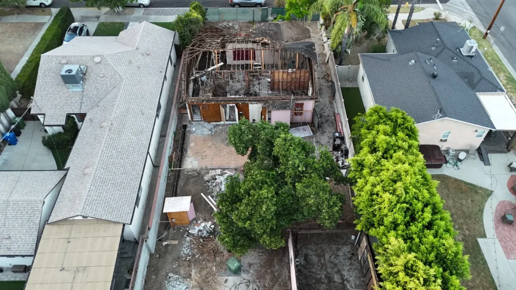 Front aerial view showing the property during roof demolition.