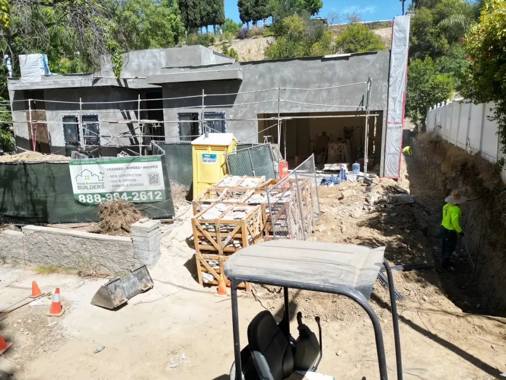 Front exterior with wall finish work and scaffolding in progress.