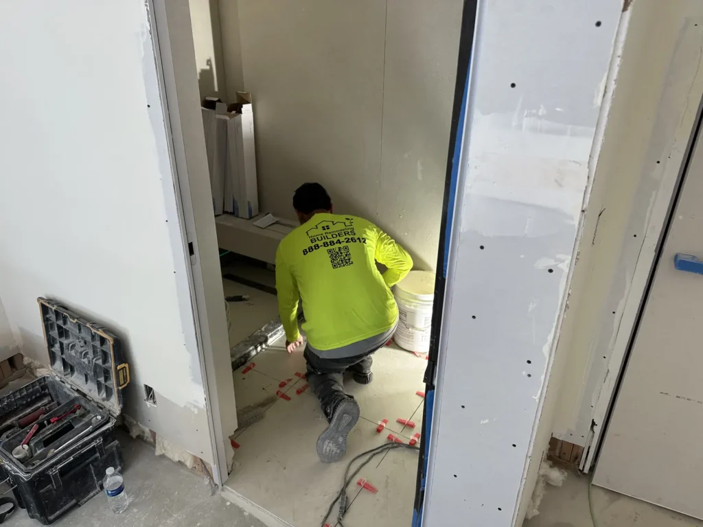 Tile installation in progress at an interior doorway.