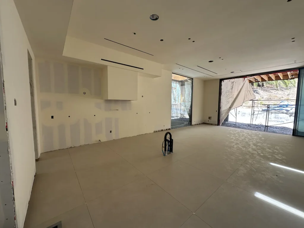 Interior room with tiled surfaces and drywall work in progress.