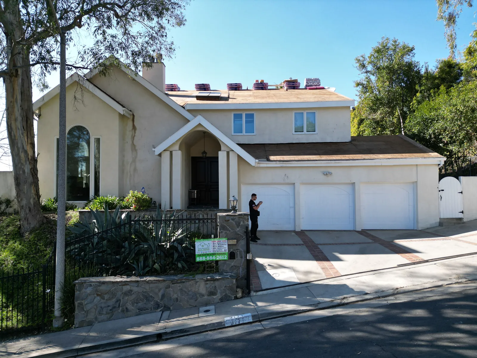 Roofing materials staged on the roof above the front elevation. Beverly Hills roofing project.