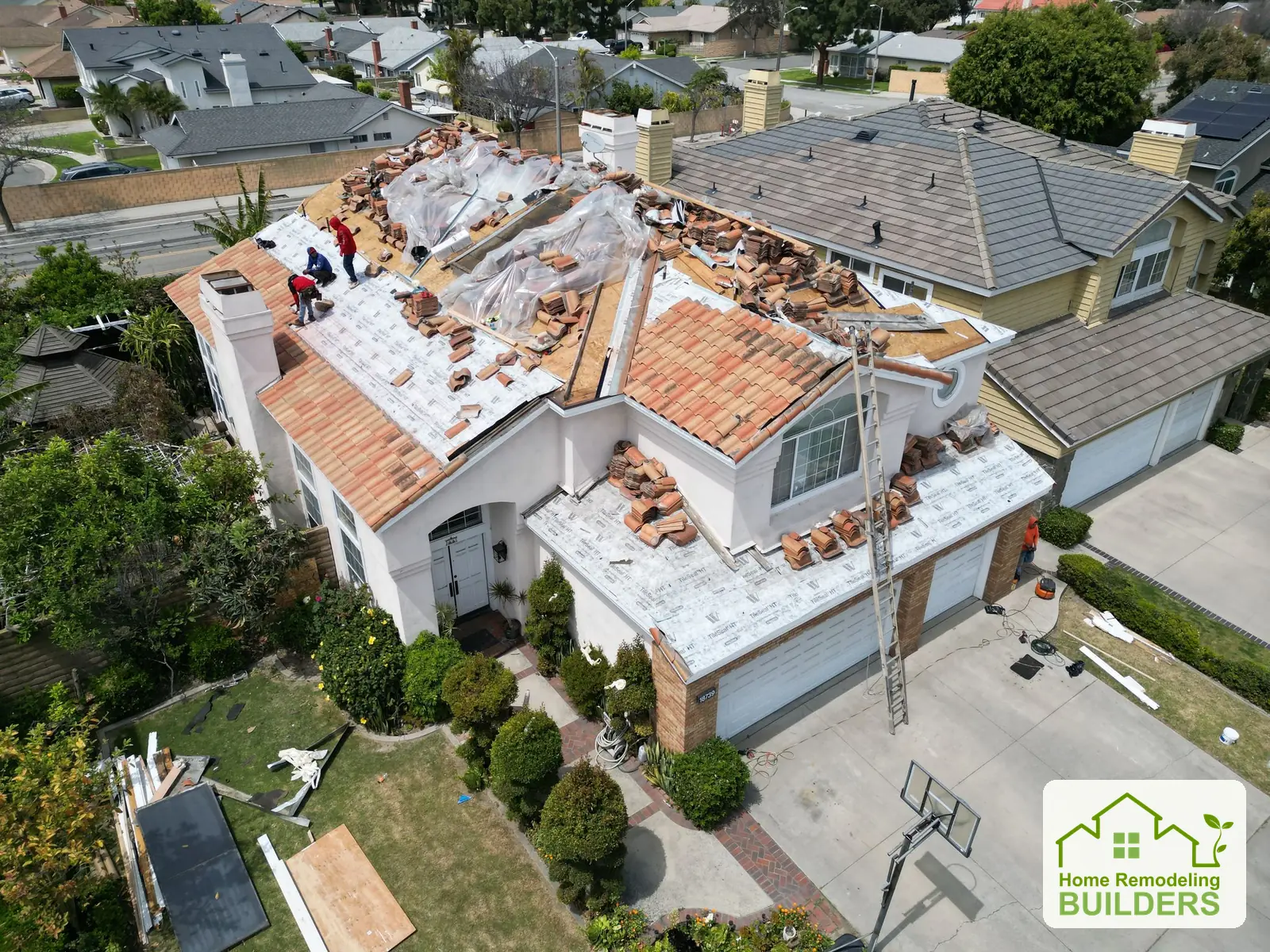 The crew working across the exposed roof and new underlayment. Cerritos roofing project.