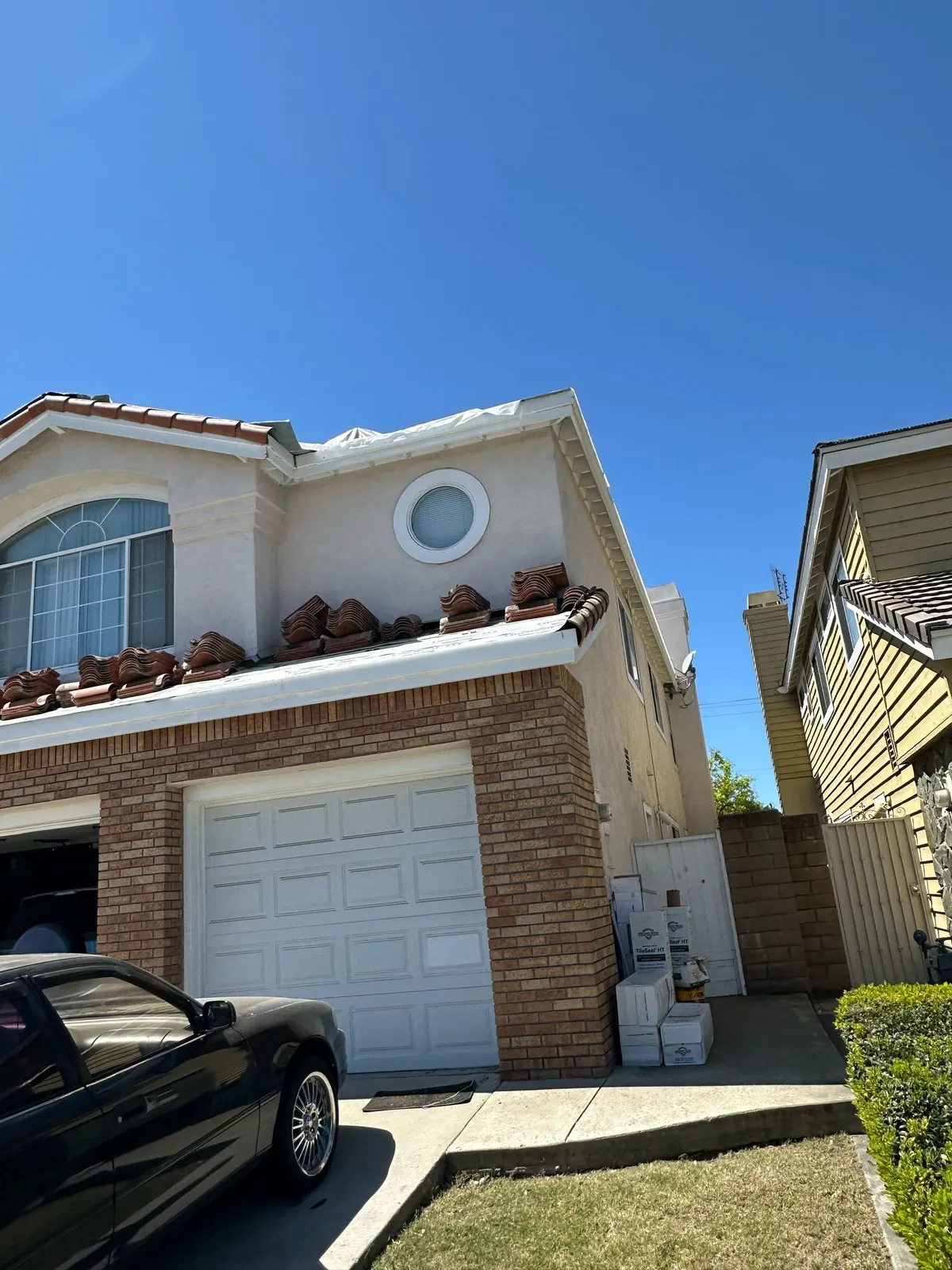 Tiles lifted and staged along the garage roof. Cerritos roofing project.