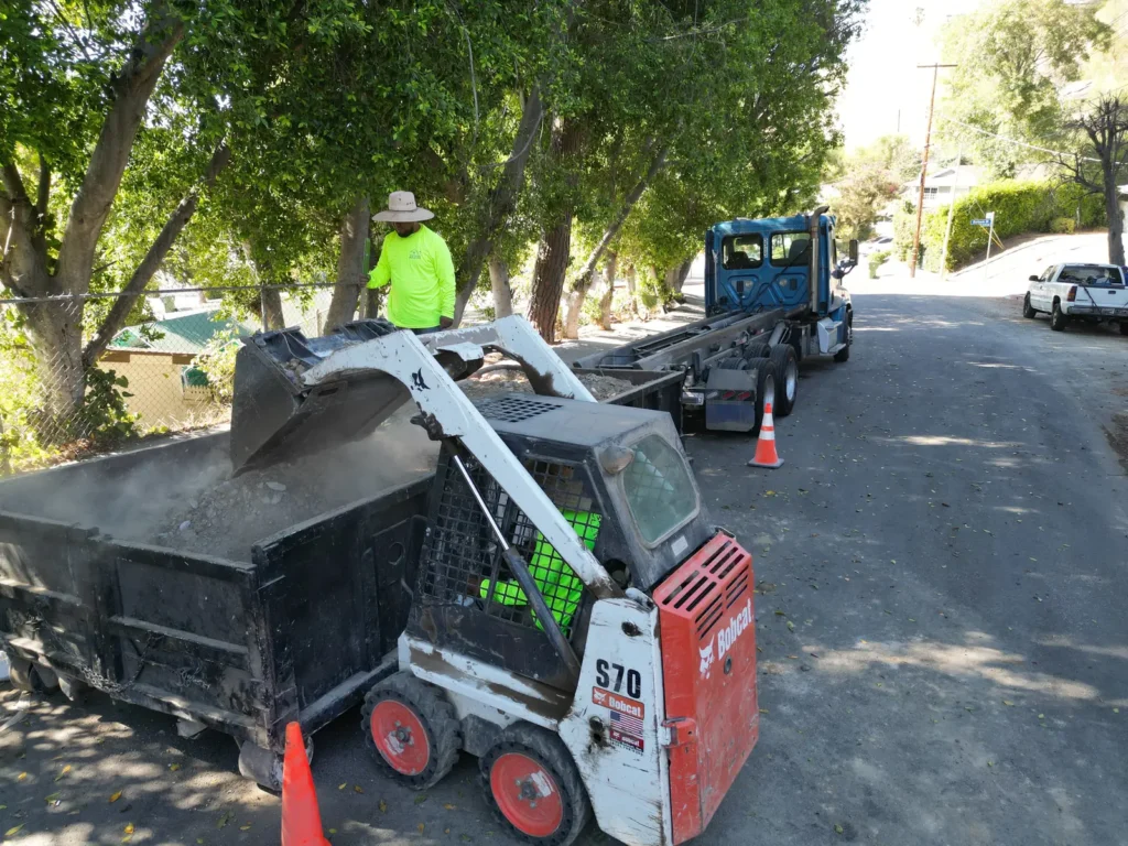 A loader and crew move excavated material during the custom home build.