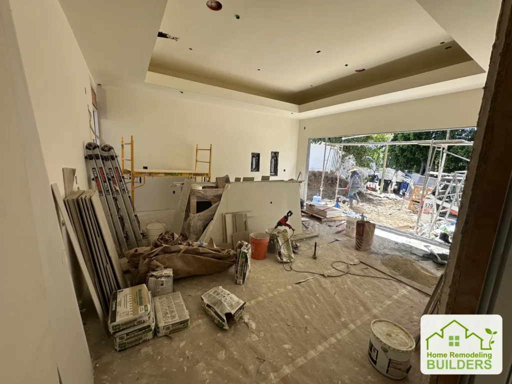 The great room during interior finishing, with the recessed ceiling and wide backyard opening visible.