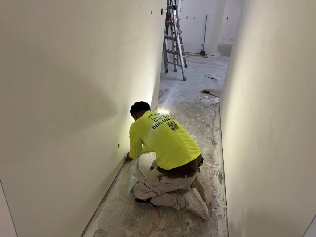 A crew member in a branded shirt prepares the interior floor edge.