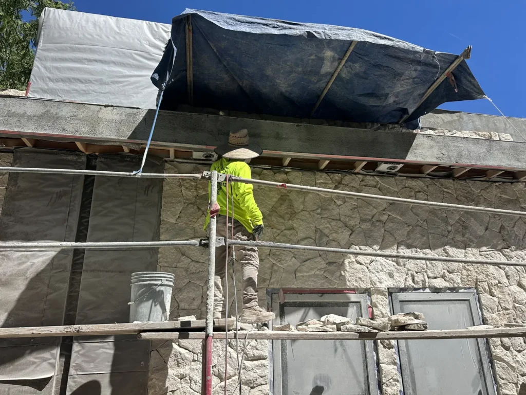 Exterior wall work during the textured stucco stage.