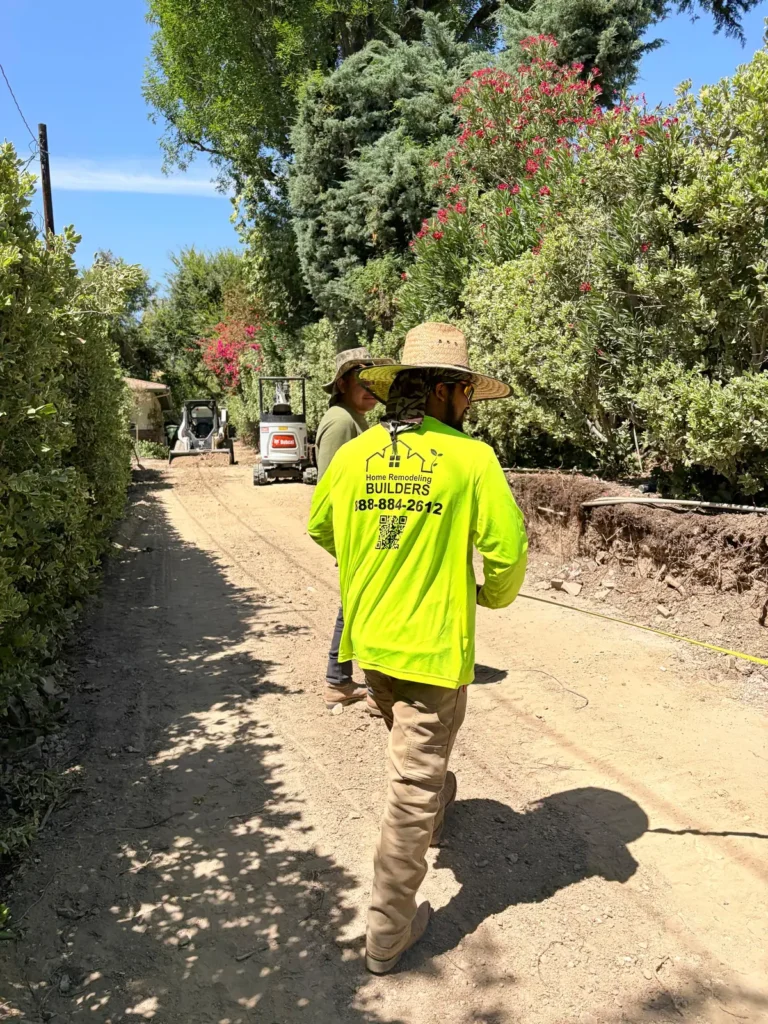 A crew member in a branded shirt walks the prepared driveway.