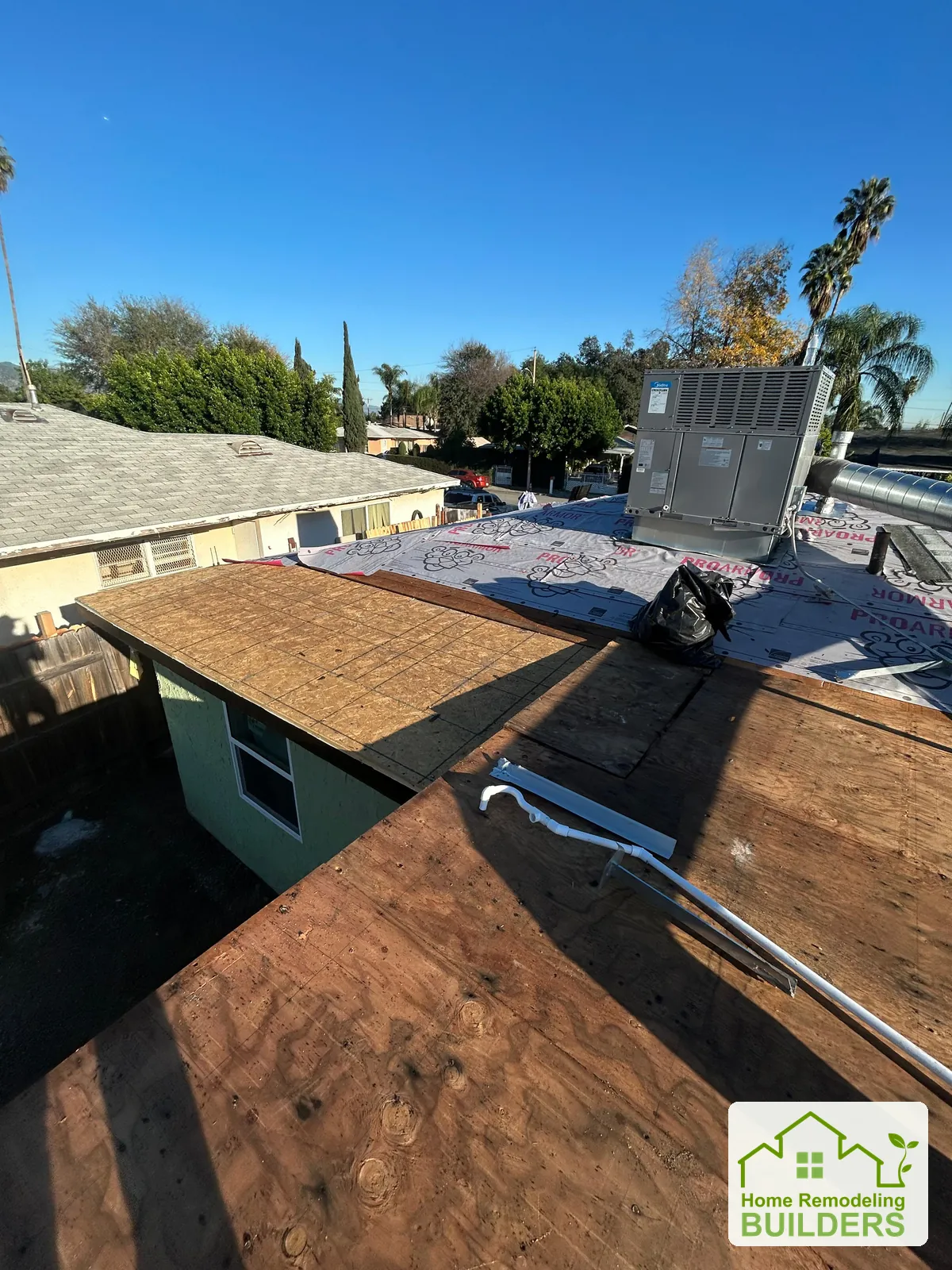 New roof sheathing being prepared around rooftop equipment. Duarte roofing project.