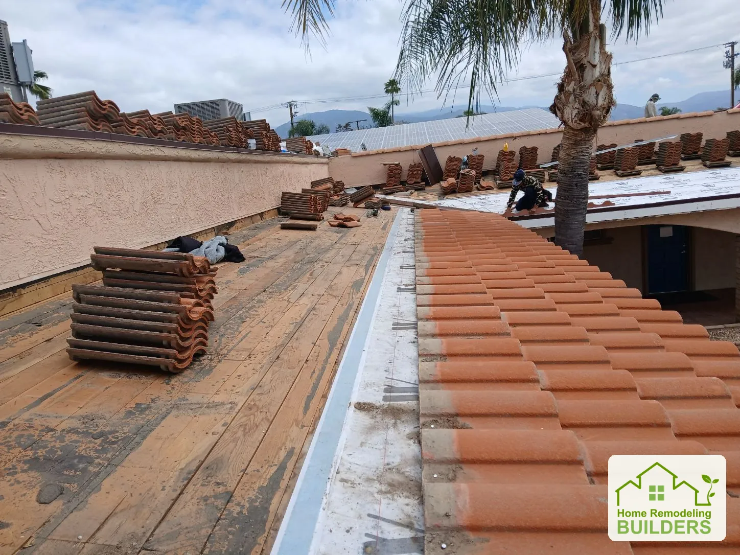 A close view of the exposed deck beside stacked roof tiles. Hemet roofing project.