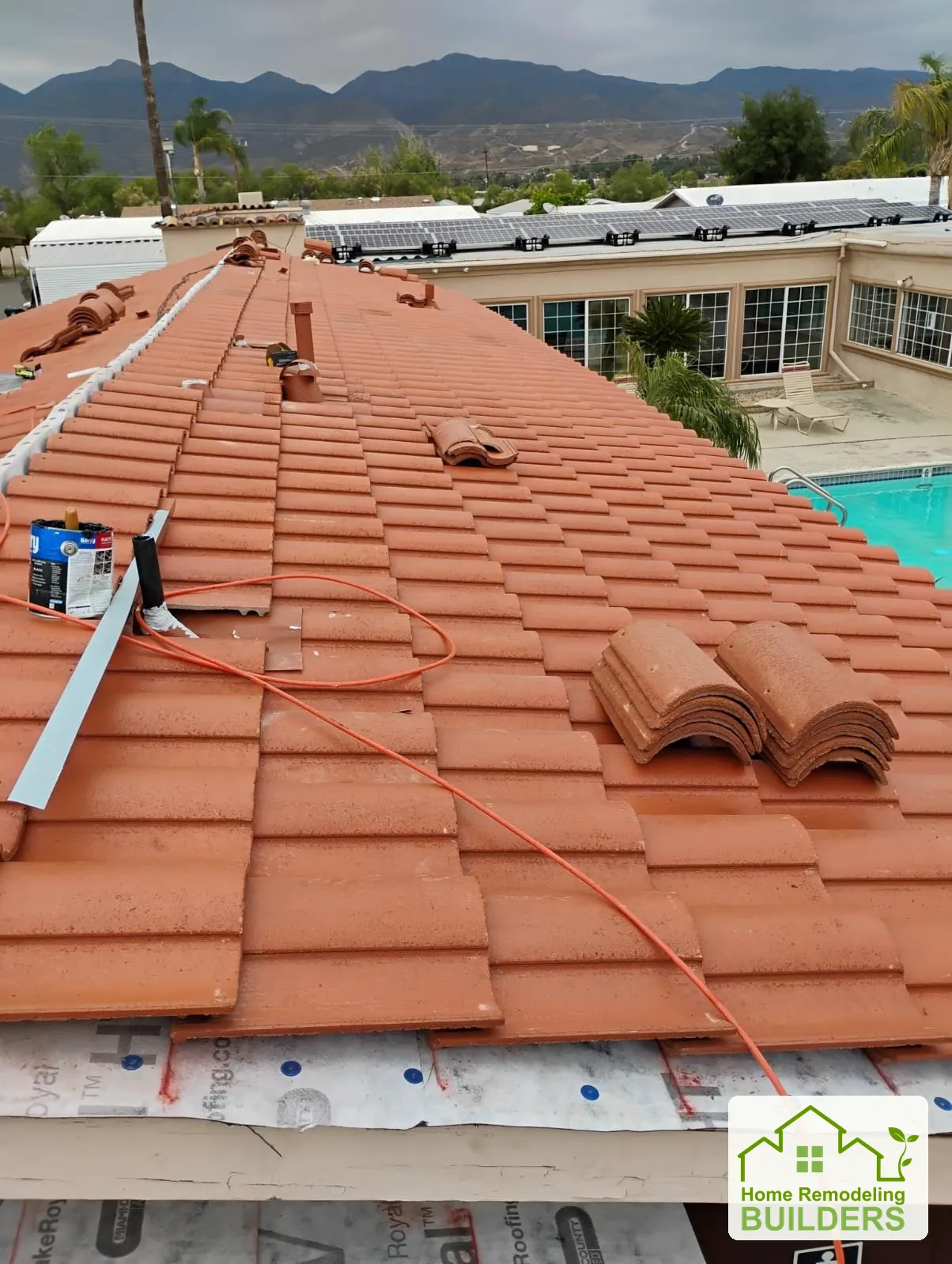 Tile installation progressing toward the roof ridge. Hemet roofing project.