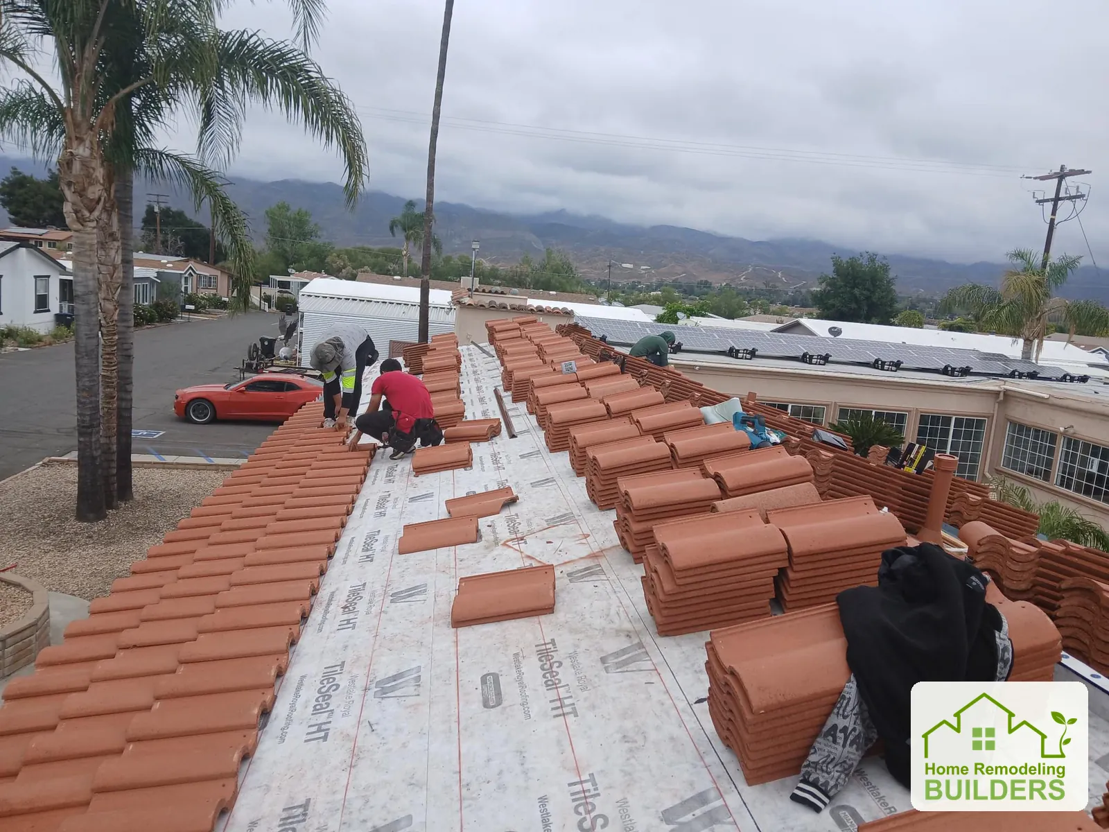 The crew lays tile courses over the prepared underlayment. Hemet roofing project.