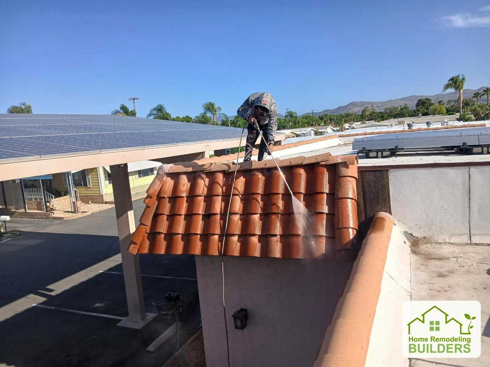 A roofer works at the edge of the courtyard roof. Hemet roofing project.
