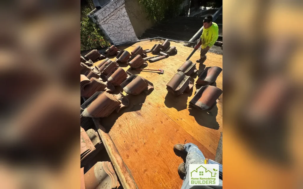 A crew member works on the exposed deck beside staged tiles. Laguna Hills roofing project.