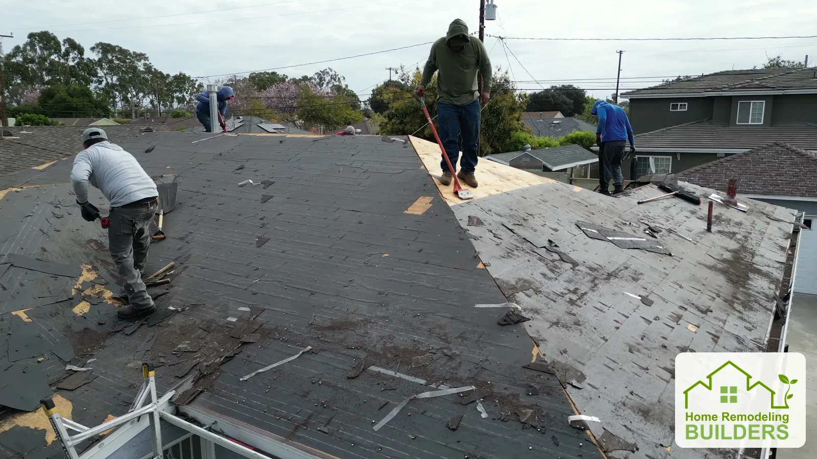 A closer view of the roofing crew removing the old roof covering. Lakewood roofing project.
