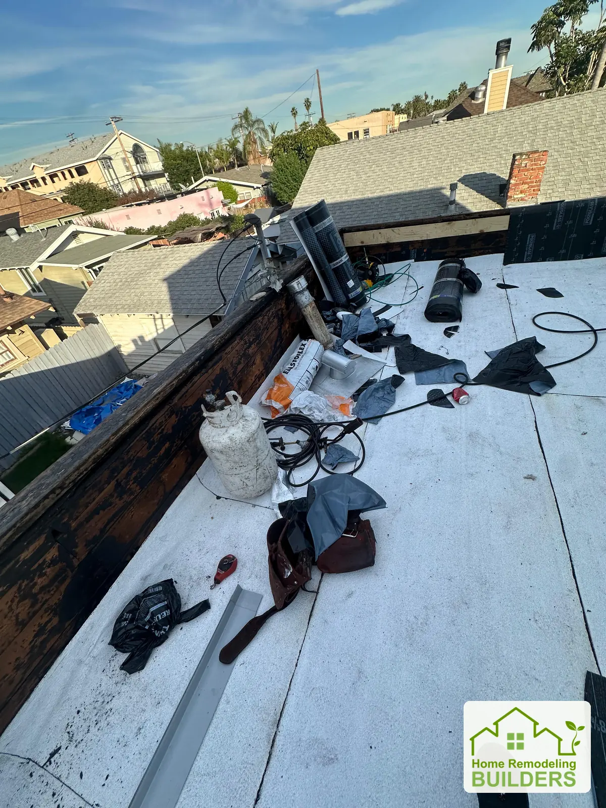 Roofing work and tools across the lower roof area. Long Beach roofing project.