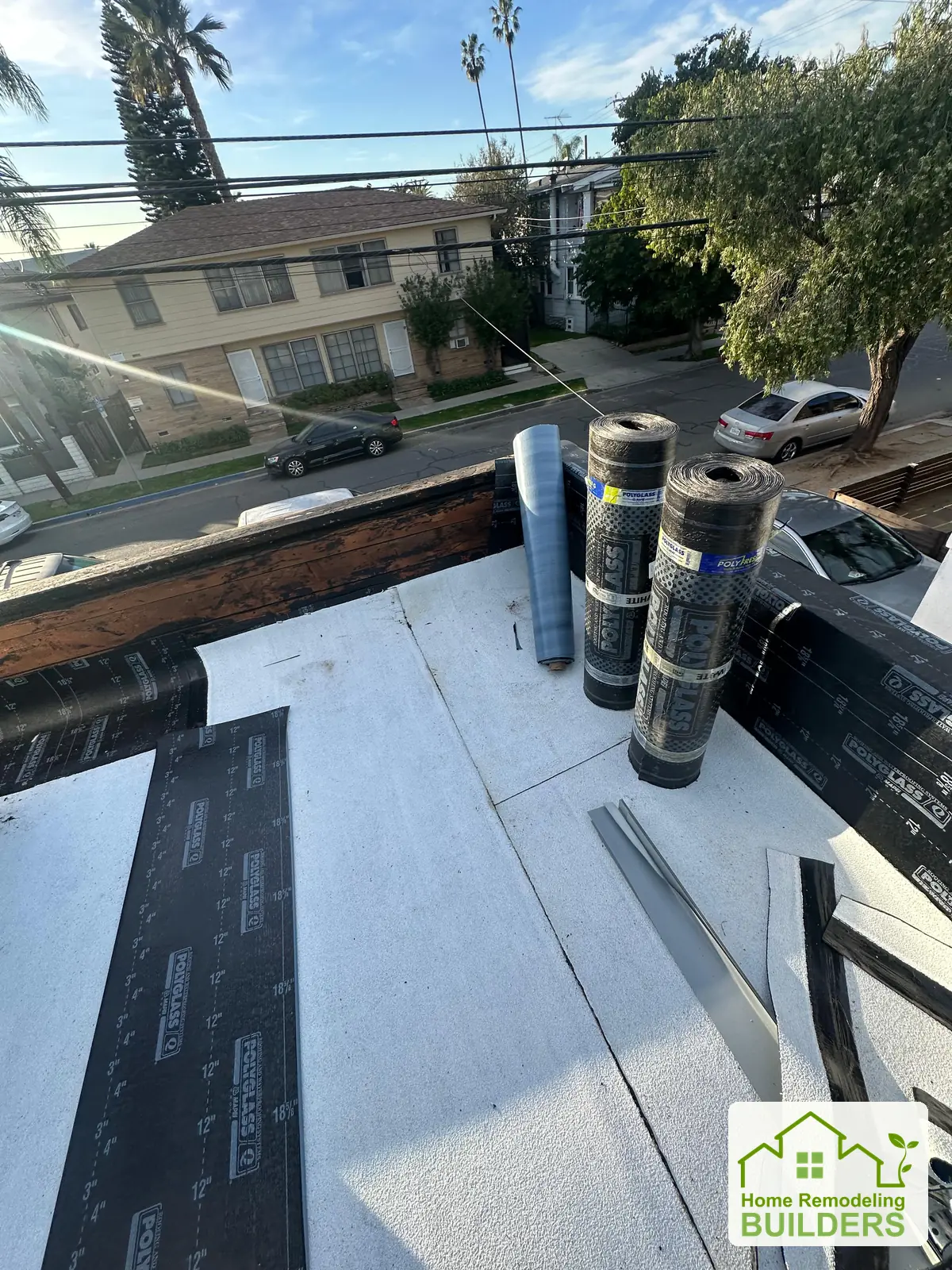 Roofing rolls staged beside the new roof surface. Long Beach roofing project.