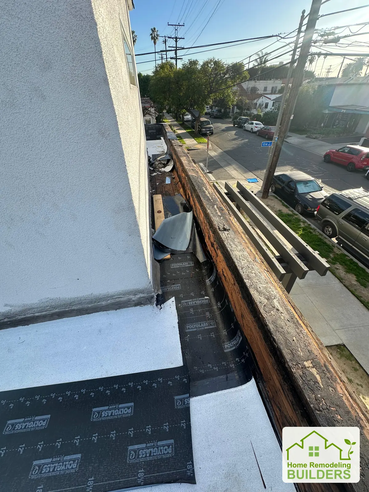 Roofing layers being installed along the wall transition. Long Beach roofing project.