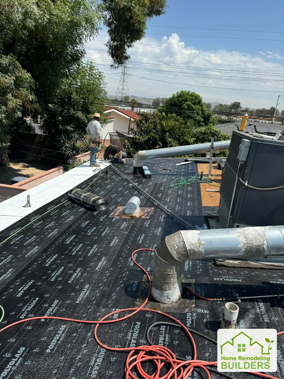 A crew member works on the prepared roof surface. Pico Rivera roofing project.