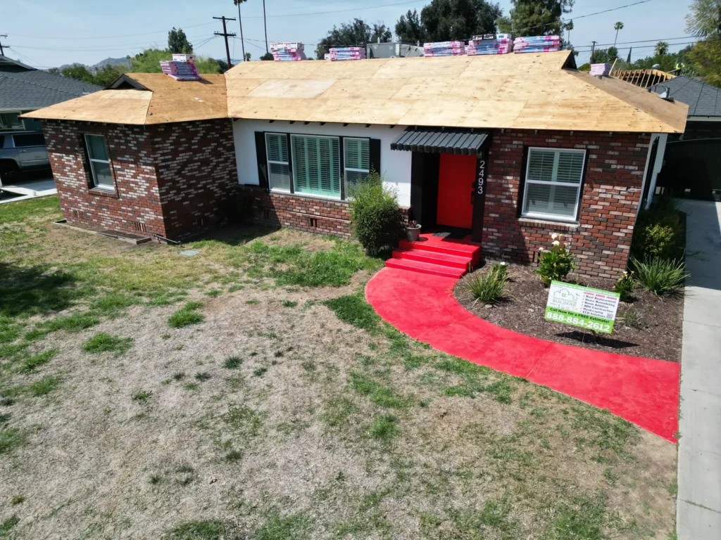 New roof sheathing above the front elevation and company sign. Riverside roofing project.