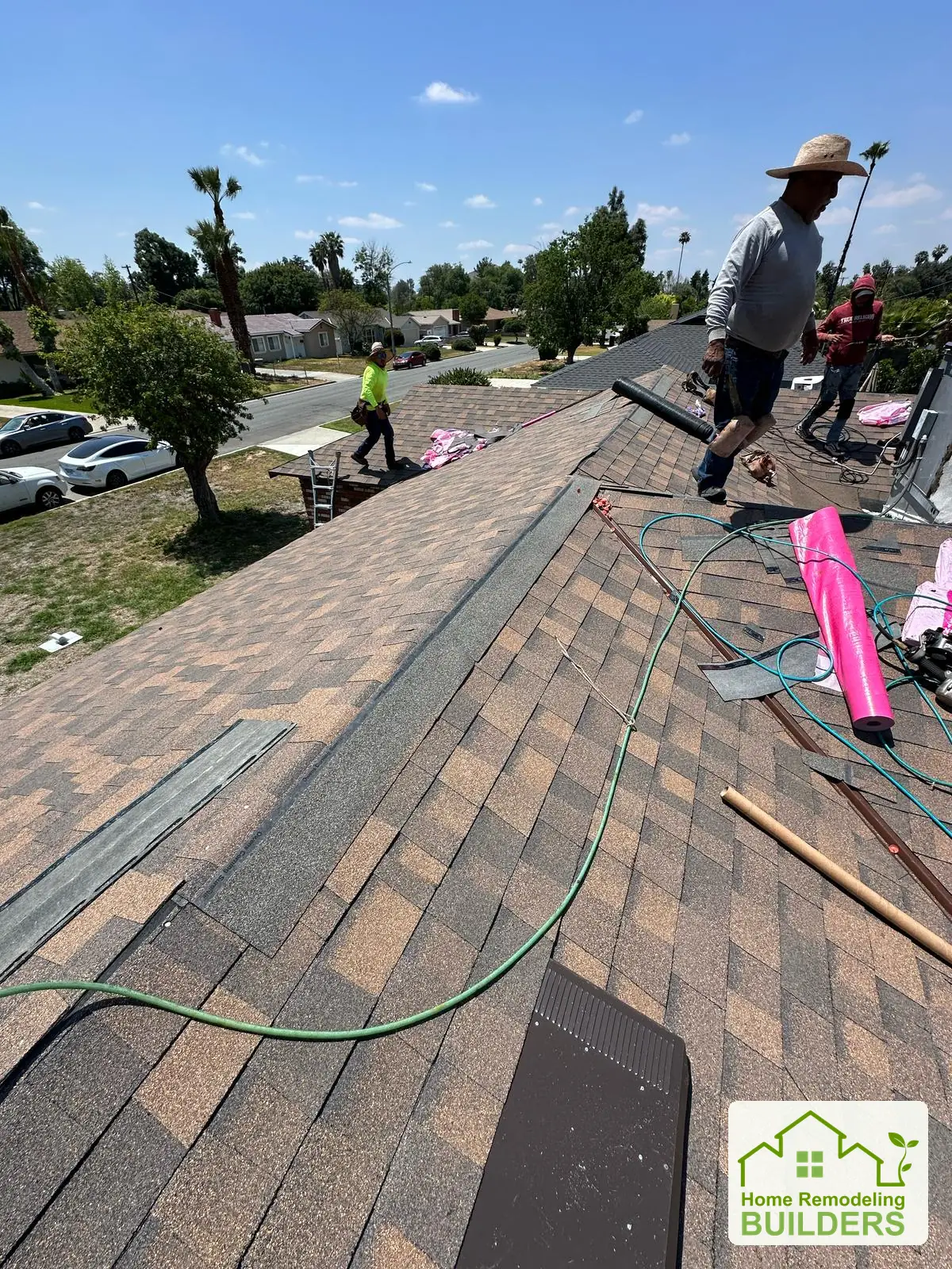 A crew member works along the roof ridge. Riverside roofing project.
