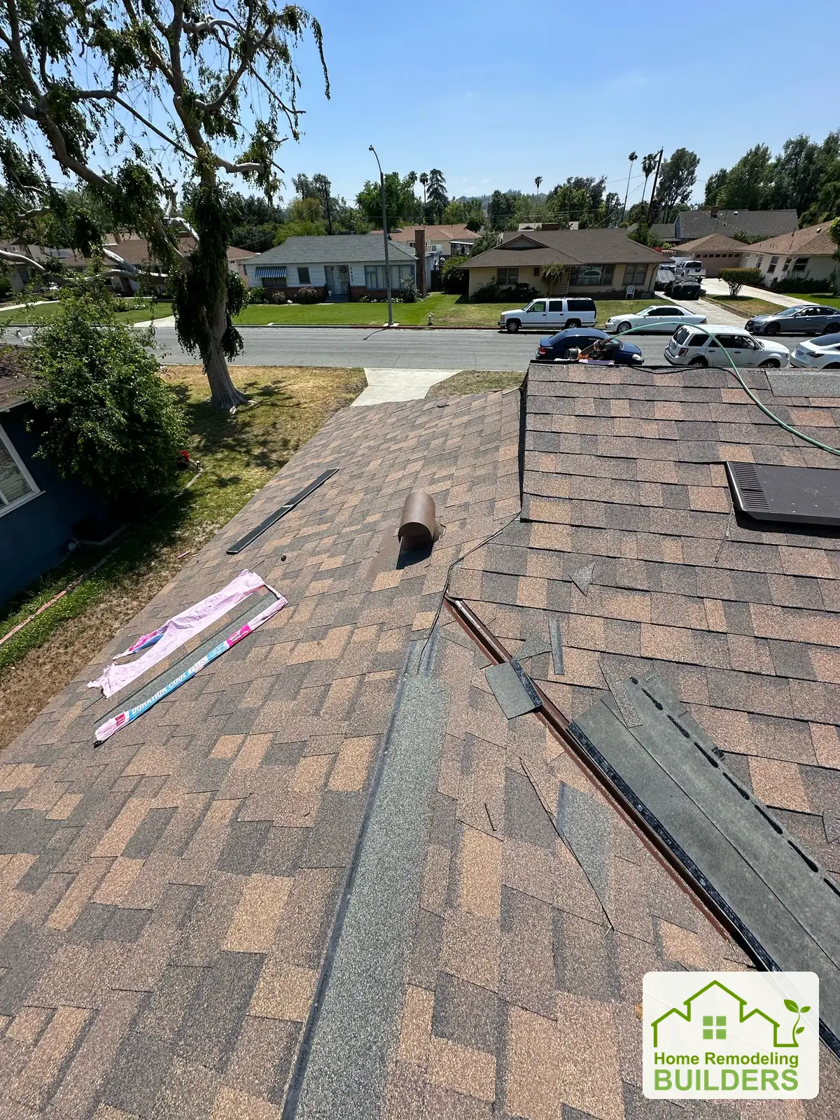Roofing details and material staging on the front slope. Riverside roofing project.