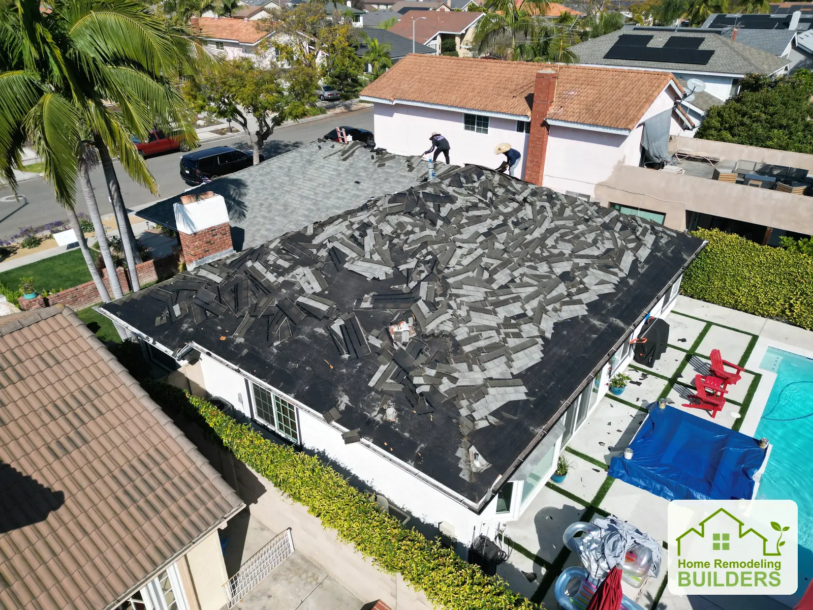 The crew removing roofing across the roof slopes. Santa Ana roofing project.