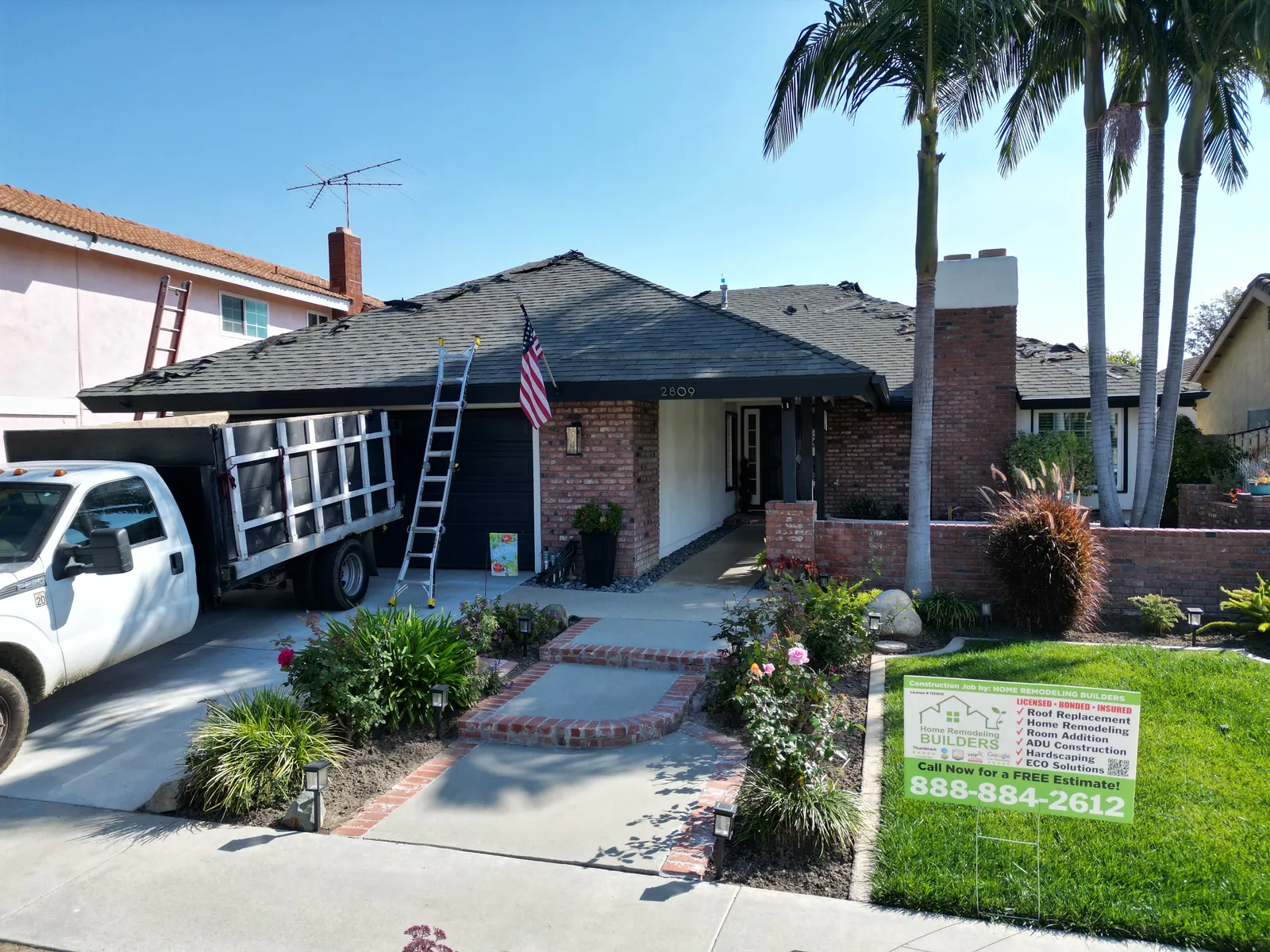 The jobsite during roof removal, with the company sign. Santa Ana roofing project.