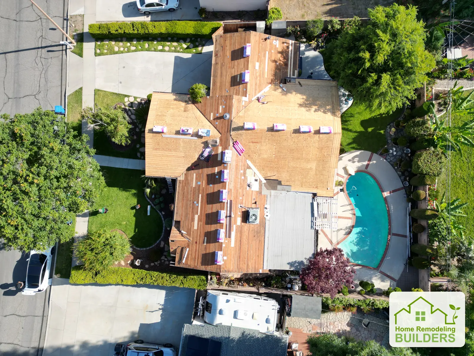 Overhead view of the exposed roof decking with roofing materials staged for installation.