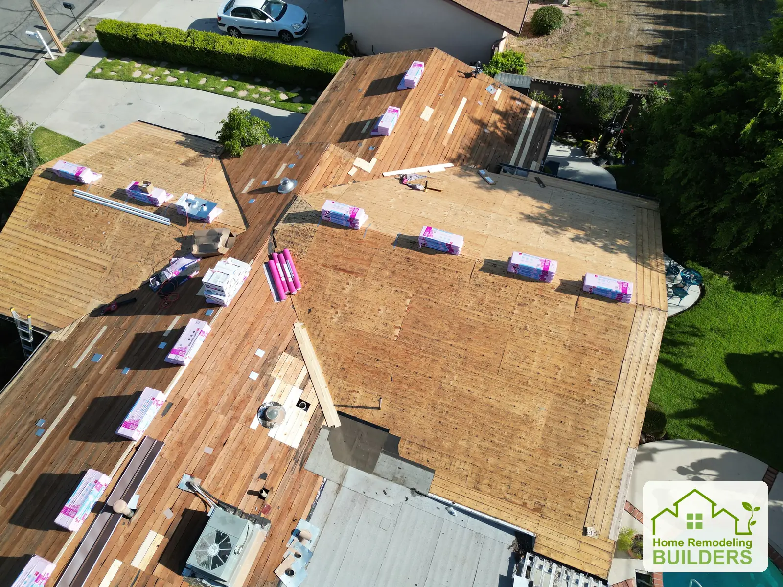 A closer view of the roof decking, valleys, vents, and staged roofing materials.