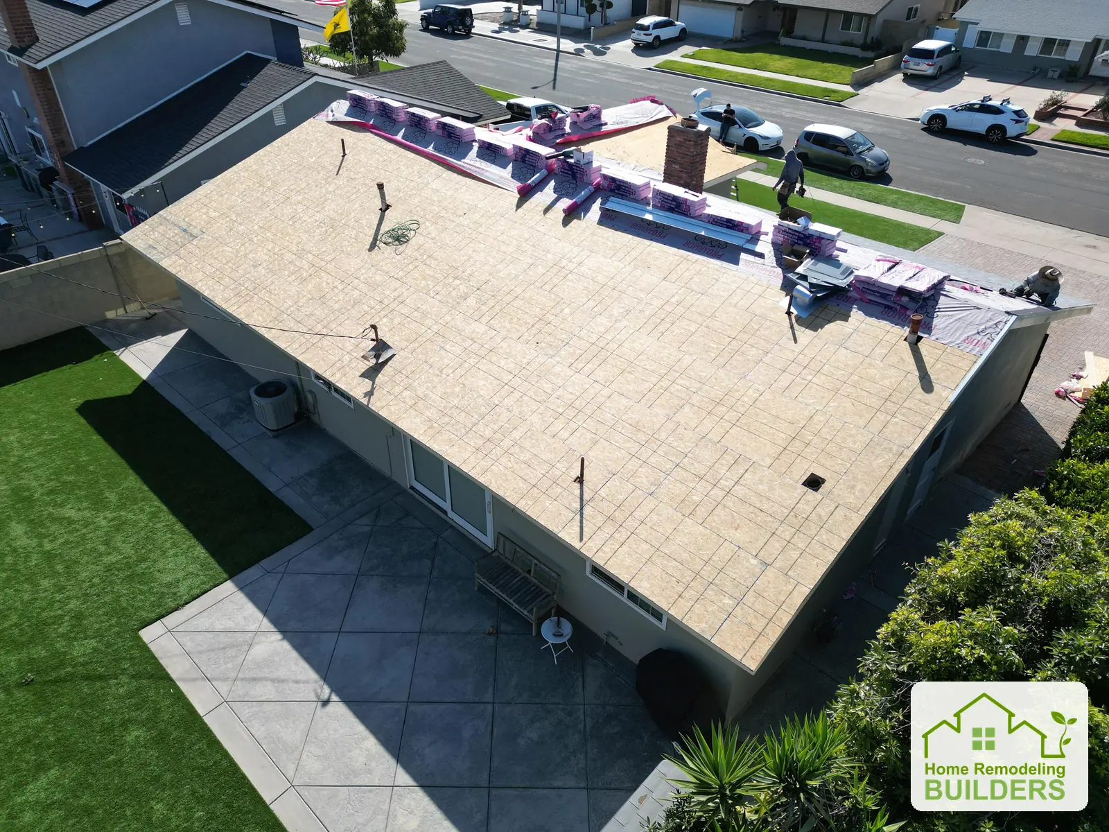 New sheathing across the roof with materials staged along the ridge. Westminster roofing project.