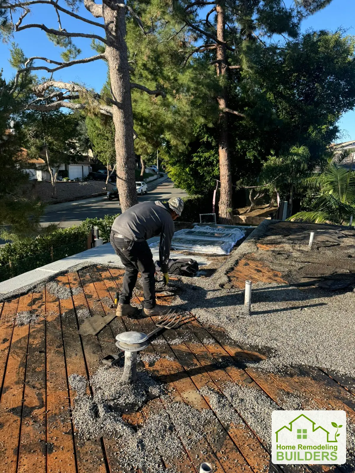 A crew member removes old roofing from the deck. Whittier Â· Flat roof roofing project.